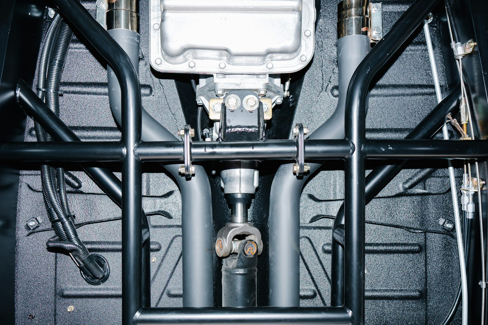 Ansicht von unten auf den Antriebsstrang und den Überrollkäfig eines Autos.